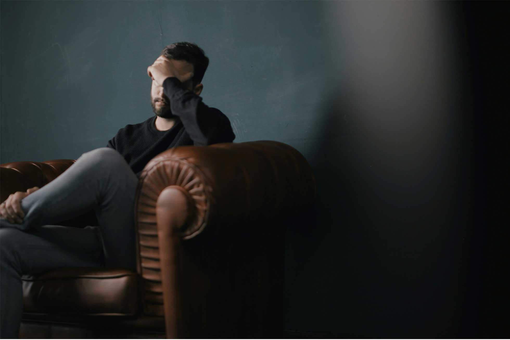 Mann hält sich die Hand an den Kopf